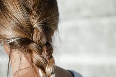 Long brown hair tied into a French braid